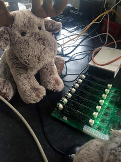 Photograph of PINE64 Clusterboard fully populated with SOPINE64 modules. Also a cuddly toy moose.